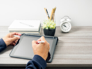 Man's hand use stylus writing on tablet pc screen, work on home