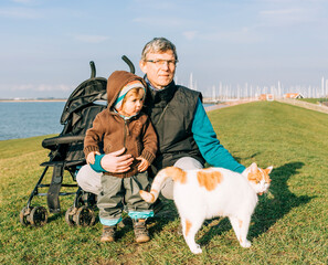 Man with toddler and cat on dyke