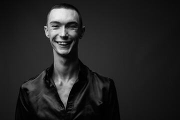 Obraz premium Young handsome androgynous businessman against gray background
