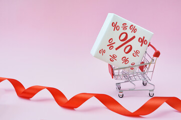 Image of empty shopping trolley or cart with box of discount percent sale black Friday products on...