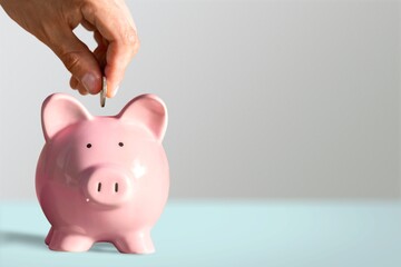 Businessman putting coin into the piggy bank