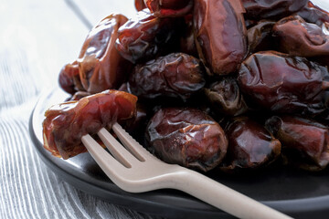 Close-up of red raw organic dates, a pile on a saucer. Healthy eating. Organic food. Delicious food. The natural background.
