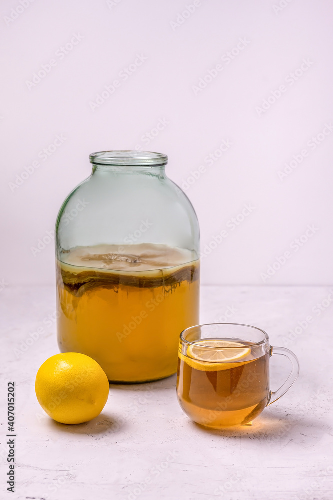 Wall mural kombucha in a glass jar and lemon on a concrete background