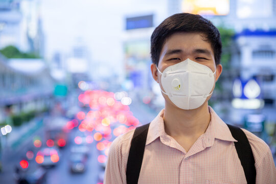 Asian man smiling behind medical protective mask in new normal lifestyle concept.