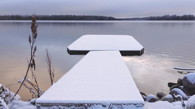 small pier covered in snow on a lakeshore