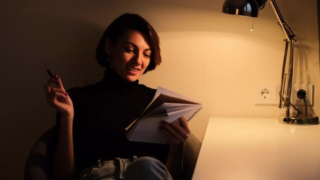 The woman in the room under the light of such a lamp writes down thoughts in a personal diary  