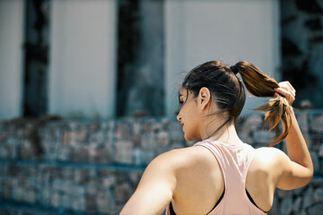 Naklejka na ściany i meble Rear view of sportswoman adjusting her ponytail.