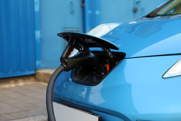 Obraz na płótnie Canvas Charging modern electric car from station outdoors, closeup