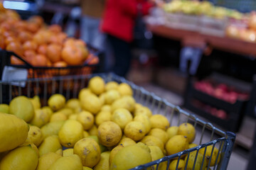 Soft focused shot of fruit department in grocery store, supermarket, mall, hypermarket or shopping center. Boxes with lemons and tangerines. Healthy eating, avitaminosis  concept.