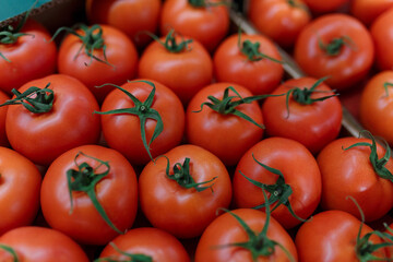 Soft focused shot of vegetable department in grocery store, supermarket, mall, hypermarket or shopping center. Boxes with tomatoes. Vegetarian organic healthy food concept.