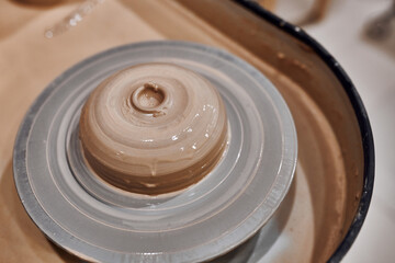 Potter's wheel with raw clay in a pottery workshop