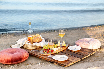Fototapeta na wymiar Food for picnic and white wine served on wooden pallet near river