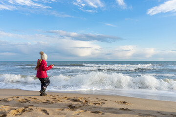 The child walks along the seashore