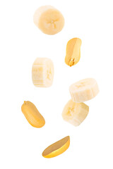 Isolated fruits and nuts. Seven flying peanuts witout shell and banana slices on white with clipping path as package design element. Full depth of field. Food levitation concept.