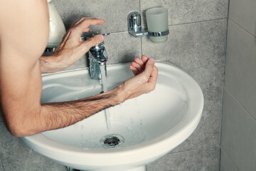 Close up of man wash hands in sink in morning