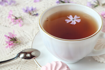 A cup of hot tea with a delicate flower in it, close-up