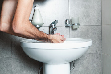 Close up of man wash hands in sink in morning