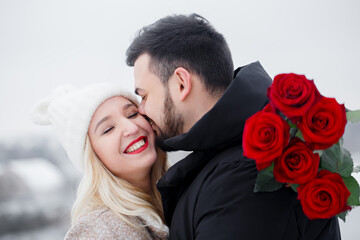 Handsome guy kissing happy girl
