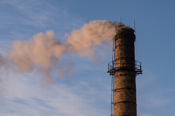 Black smoke from the chimney. Boiler house chimney made of bricks.