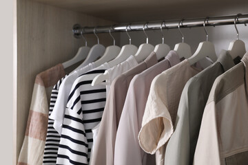 Wardrobe with different stylish clothes indoors, closeup
