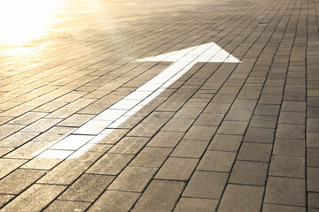 White painted arrow marking on road outdoors