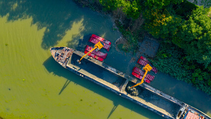 Fototapeta na wymiar Aerial view of river, canal is being dredged by excavator