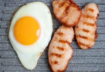 Cooking chicken fillet in a grill pan at home. fried egg. Breakfast for one. Grill fresh chicken breast. Fry the chicken in a grill pan. Chicken egg cooked in a pan. High quality photo