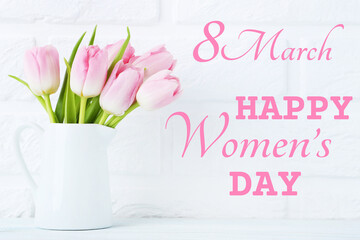 Bouquet of tulips in jug with text Happy Womens Day on brick wall background
