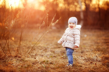 early spring, girl walking on the street, buds swollen, sunset evening in spring