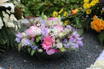 Bunte Blumen schmücken ein Grab nach Beerdigung