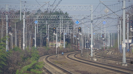 Tory kolejowe przy dworcu kolejowym w Żorach w Polsce. Torowisko biegnie między słupami zasilającej sieci trakcyjnej i sygnalizacyjnymi