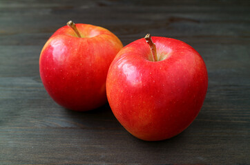 Pair of fresh ripe red apple isolated on dark colored wooden background