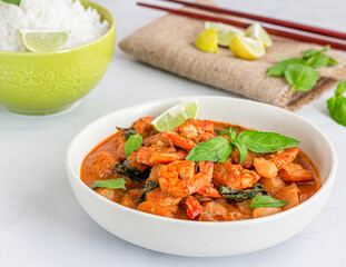 Thai Massaman Curry with Shrimp in a Bowl Served with Rice and Lemon, Garnished with Basil