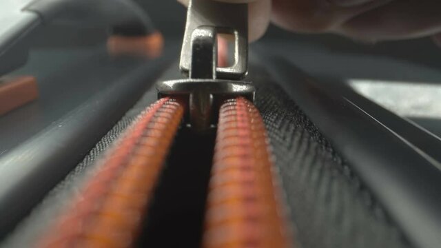 Opening of the closed zipper of the black luggage bag as seen on a closer look in Estonia