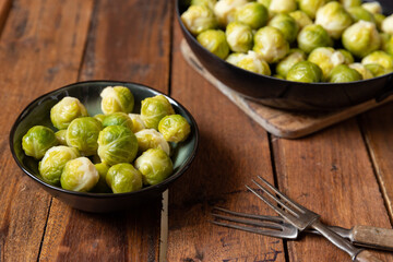 gekochter grüner Rosenkohl in Topf auf einem Tisch aus  braunem Holz in der Küche