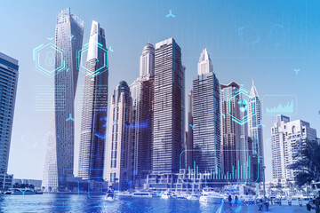 Fototapeta premium Skyscrapers of Dubai business downtown. International hub of trading and financial services. Technology theme icons hologram, Fintech concept. Double exposure. Dubai Canal waterfront.