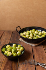 gekochter grüner Rosenkohl in Topf auf einem Tisch aus  braunem Holz in der Küche
