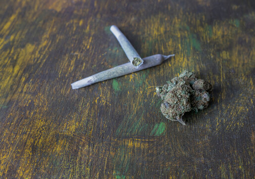 Buds of marijuana, and cannabis rolled joints on abstract wooden background.Medical and medicine concept.