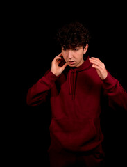 Fototapeta na wymiar Attractive young man with curly hair posing on black studio background