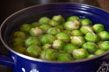 gekochter grüner Rosenkohl in Topf auf einem Tisch aus  braunem Holz in der Küche