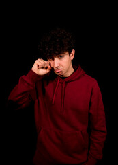 Obraz premium Attractive young man with curly hair posing on black studio background