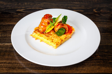 Meat rolls on an omelette with spinach and caramel sauce