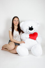 Girl with soft toy on white background