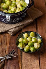 gekochter grüner Rosenkohl in Topf auf einem Tisch aus  braunem Holz in der Küche