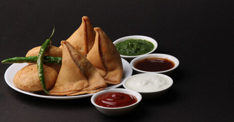 Kachori and samosa, Indian vegetarian snacks served with  green and tamarind chutneys.