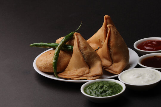 Kachori and samosa, Indian vegetarian snacks served with  green and tamarind chutneys.
