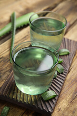 Fresh aloe drink in glasses on wooden table