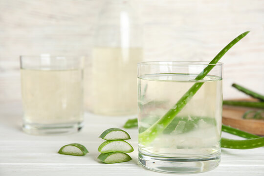 Fresh aloe drink on light wooden table, closeup. Space for text