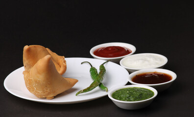 Indian snack Homemade spicy and delicious samosa served with green, tamarind chutney.