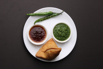 Indian snack Homemade spicy and delicious samosa served with green, tamarind chutney.